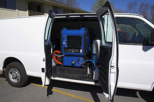 van with side doors open showing cleaning equipment for carpet, tile grout, and upholstery