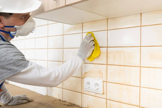 Man cleaning yellow grout