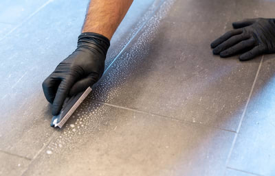 man with gloves doing grout cleaning